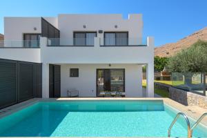 una villa con piscina di fronte a una casa di Villa Lambis Harmonia a Líndos Altre 13 foto