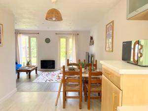 a kitchen and living room with a table and chairs at Artistic, Bright & Spacious 3 Bedroom Home in Kirkstall