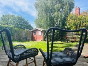 two chairs sitting on a deck with a yard at Artistic, Bright & Spacious 3 Bedroom Home in Kirkstall