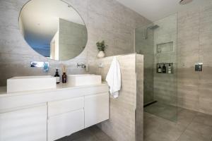 a bathroom with two sinks and a mirror at Werri Big Beach House in Gerringong +34 photos