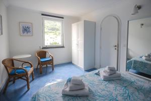 una camera da letto con un letto, due sedie e uno specchio di Attico Panoramico ad Anacapri