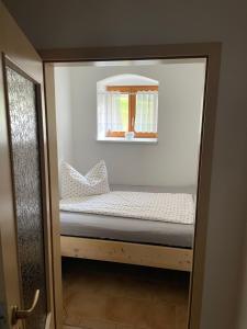 Una cama pequeña en una habitación con ventana. en Energietanken vor den Toren Dresdens -barrierefrei-, en Dippoldiswalde