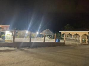 a fence at night with lights in the background at DadaG's Guest House in Punta Gorda