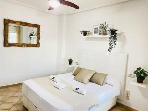 a white bedroom with a bed with towels on it at La Almadraba in Chiclana de la Frontera +130 photos