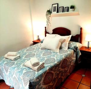 a bedroom with a bed with two towels on it at Alhambra Catedral Centro in Granada