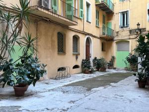 un vicolo con piante in vaso di fronte a un edificio di Suite Pascal by Monarca Business and Holidays - Bastia a Bastia