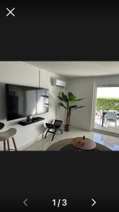 TV a/nebo společenská místnost v ubytování Appartement PIEDS DANS L'EAU VUE MER ACCES PLAGE ET PISCINE
