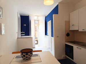 a kitchen with blue walls and a table with a vase on it at Casa cobalto vicinissima al centro by Turin House Collection in Turin +17 photos