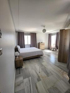 Mont Blanc :Appartement, vue sur mer à 2 minutes de la gare. في طنجة: غرفة نوم بسرير أبيض وأرضية خشبية