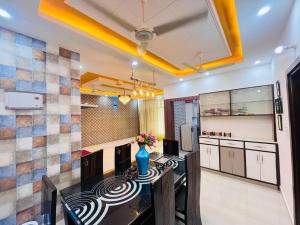 a kitchen with a counter with a vase of flowers on it at ANAisha mansION Near Helipad Rajpur Road shastradhara Hill View in Dehradun +32 photos