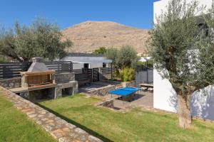 a backyard with a picnic table and a grill at Villa Lambis Athena in Líndos
