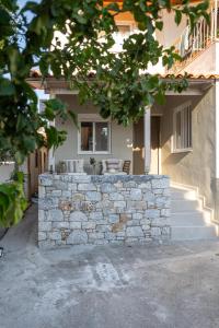 a house with a stone wall in front of it at Ammos Stoupa - Cosy Casa in Stoupa