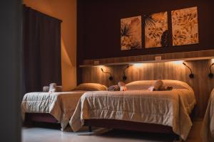 two beds in a hotel room with lights on them at Hotel Boutique Genova in Puerto Iguazú +39 photos