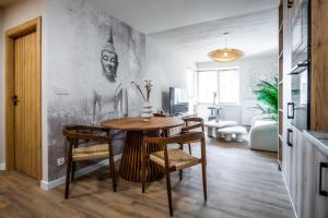 a dining room with a table and chairs in a room at Apartamenty Balijskie in Gliwice