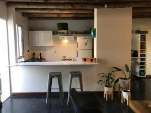 a kitchen with a counter and two stools at Corazón de Manzana in Ciudad Lujan de Cuyo
