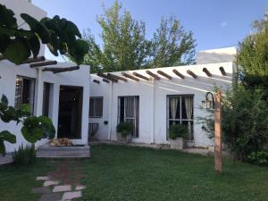 a dog laying in the yard of a white house at Corazón de Manzana in Ciudad Lujan de Cuyo