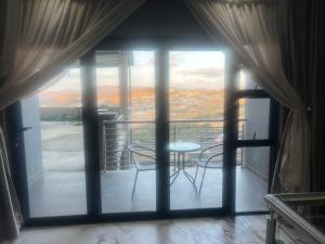 Una habitación con balcón con mesa y sillas. en Mountain Top Luxury Villas, en Mbabane