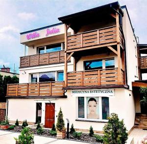 a building with a sign on the side of it at Willa Julia-pokoje w centrum, ogród, sauna, grill in Ustroń