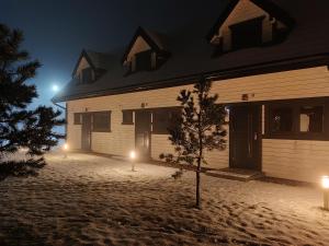 a house with lights in front of it at night at Osada Jantar - Holiday in Jantar