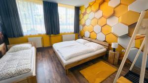 a bedroom with two bunk beds and a yellow and white wall at Apartmány SVRČINKY in Liptovský Mikuláš