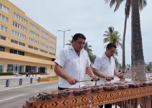 two men standing next to a table with bricks at Hotel Hostal de Cortés in Veracruz