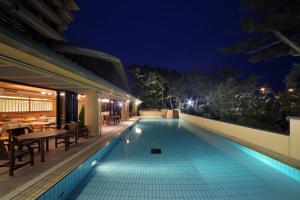 a swimming pool in the middle of a house at night at Kamogawakan in Kamogawa