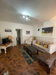 ein Wohnzimmer mit Sofa und Tisch in der Unterkunft CASA BARRIO UNIVERSITARIO Nicaragua 920 in Bahía Blanca