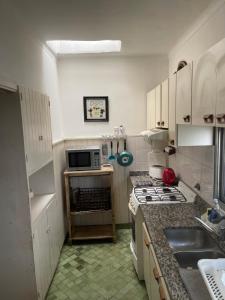 eine Küche mit Spüle und Herd oberen Backofen in der Unterkunft CASA BARRIO UNIVERSITARIO Nicaragua 920 in Bahía Blanca