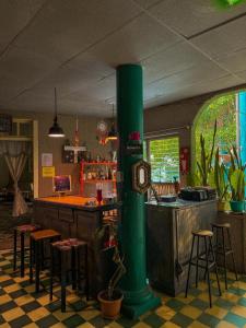 a green pole in a restaurant with a bar at Hotel Brunette in Santa Ana