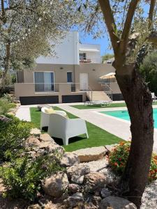 a yard with a white bench and a house at Villa dei Mori in Capitana