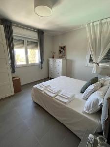 a bedroom with a large white bed with towels on it at Villa dei Mori in Capitana