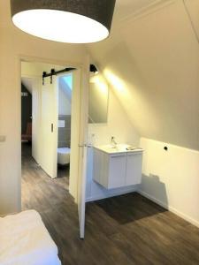a bathroom with a white sink and a bed at De Brittenburg 4-persoons, finse sauna, hottub, sunshower, grote zonnige omheinde tuin, wifi en huisdier vriendelijk in Lievelde +71 photos