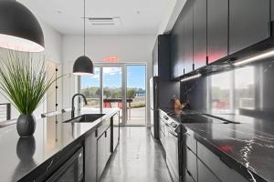 a kitchen with black and white counters and a sink at Grand Prix Grandeur at AMP in Dawsonville