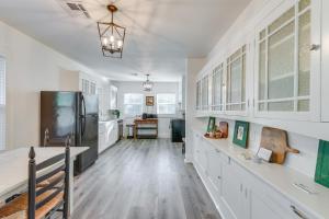 a kitchen with white cabinets and a refrigerator at Waco Vacation Rental Near Magnolia Market in Waco