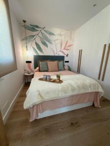 ein Schlafzimmer mit einem Bett mit einem Blumenwandbild an der Wand in der Unterkunft La terraza de quintana in Oviedo