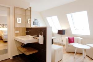 a bathroom with a sink and a mirror and a chair at City Hotel MAX Munich West in Munich +48 photos