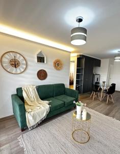 a living room with a green couch and a table at Bello departamento in Los Ángeles