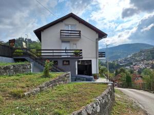 une maison blanche sur le côté d'une route dans l'établissement Apartman Look, à Jajce