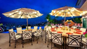 a table with chairs and umbrellas on a balcony at Casa Ivonne in Puerto Vallarta