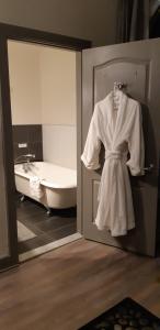 a robe hanging in a bathroom with a bath tub at Oberge Inn Val-David in Val-David +37 photos
