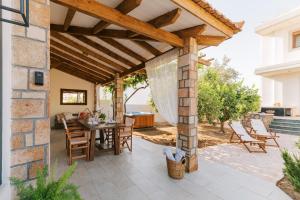 an outdoor patio with a wooden pergola at La Casetta della Nonna in Lartos