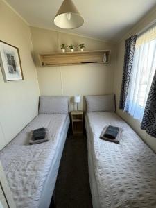two beds in a small room with at Comfy Cosy Caravan_Romney Sands in Littlestone-on-Sea +18 photos