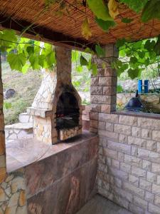 an outdoor brick oven in a patio with a roof at Garden House in Tuzla