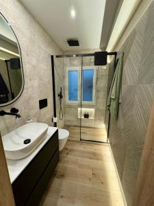 ein Badezimmer mit Waschbecken, Toilette und Spiegel in der Unterkunft La terraza de quintana in Oviedo