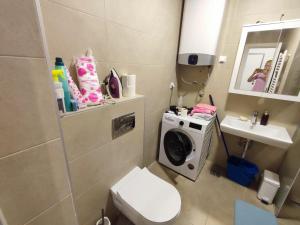 Un baño con inodoro y lavadora. en Room in a nice sunny apartment, en Vračar (historical)