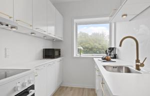 Frederiksbergにある2 Bedroom Cozy Apartment In Randers Svのシンクと窓のある白いキッチン