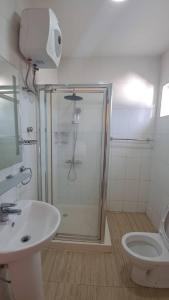 a bathroom with a shower and a sink and a toilet at American Mall apartment, Osu in Accra +10 photos
