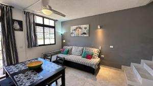 a living room with a couch and a table at Las Fresas Apartments in Puerto Rico de Gran Canaria
