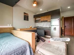 a bedroom with a bed and a kitchen with a refrigerator at New Loft with Sky Bar and Pools in Oaxtepec