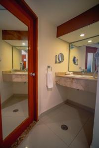 a bathroom with two sinks and a mirror at Hotel Hostal de Cortés in Veracruz